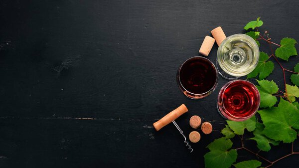 красное и белое вино в стаканах. Виноград. На черном деревянном фоне. Свободное место для текста. Вид сверху
.