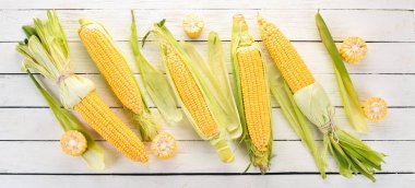 Beyaz ahşap bir masa üzerinde taze sarı Mısır. Sebze. Üstten görünüm. Kopya alanı.