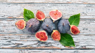 İncir. Beyaz ahşap bir masa üzerinde incir, taze meyve. Metin için özgür yer. Üstten görünüm.