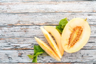 Kavun. Kavun parçalara dilimlenmiş. Beyaz ahşap zemin üzerinde. Metin için özgür yer. Üstten görünüm.