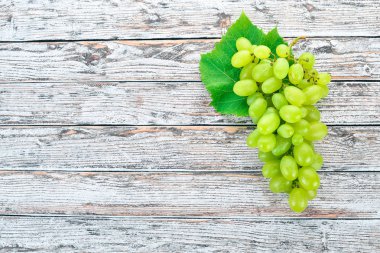 Üzüm. Beyaz ahşap zemin üzerinde taze beyaz üzüm. Üstten görünüm. Metin için boş alan.