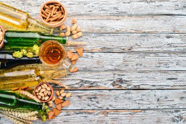 Arka plan bira ve aperatifler. Atlama, bira, cips, Kuruyemiş. Beyaz ahşap zemin üzerinde. Metin için özgür yer. Üstten görünüm.