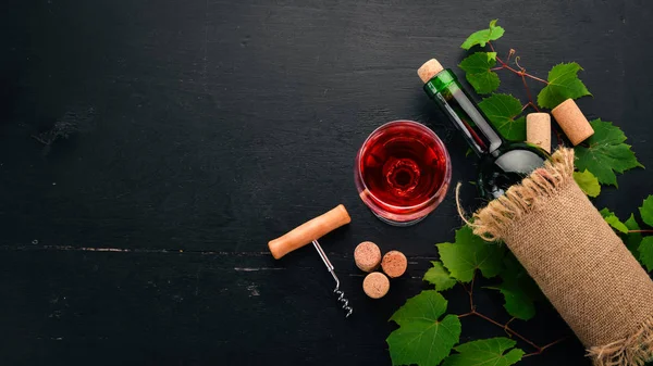 Rött Vin Flaska Med Ett Glas Och Druvor Svart Trä — Stockfoto