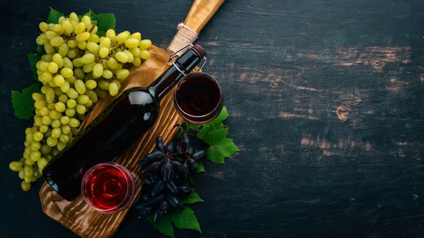 Vino Tinto Botella Con Copa Uvas Sobre Fondo Madera Negro —  Fotos de Stock