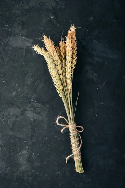 Wheat on a black stone background. Free space for text. Top view.