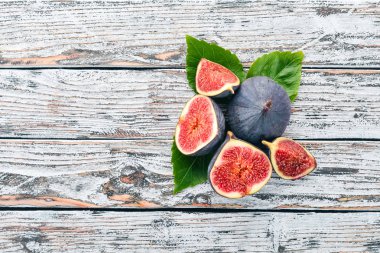 İncir. Beyaz ahşap bir masa üzerinde incir, taze meyve. Metin için özgür yer. Üstten görünüm.