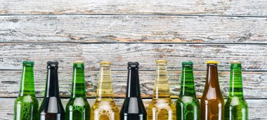 Bira şişeleri büyük bir seçim. Beyaz ahşap bir masa üzerinde. Metin için özgür yer. Üstten görünüm.