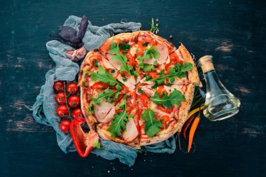 Sosis, kırmızı biber ve roka pizza. İtalyan mutfağı. Ahşap bir arka plan üzerinde. Metin için özgür yer. Üstten görünüm.