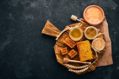 Arıcılık ürünleri ve bal siyah bir taş zemin üzerine bir dizi. Metin için özgür yer. Üstten görünüm.