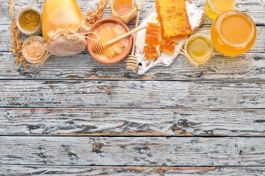 Arı ürünleri ve bal beyaz ahşap zemin üzerinde kümesi. Metin için özgür yer. Üstten görünüm.