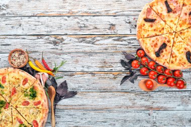 Pizza. İtalyan mutfağı. Beyaz ahşap zemin üzerinde. Metin için özgür yer. Üstten görünüm.
