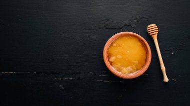 Kavanozdaki bal siyah ahşap bir arka planda. Metin için boş alan. Üst görünüm.