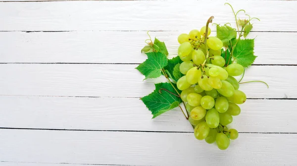 Grape. Fresh white grapes on a white wooden background. Top view. Free space for text.