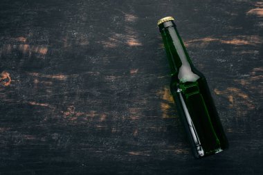 Bir şişe bira ahşap arka plan üzerinde. Metin için özgür yer. Üstten görünüm.
