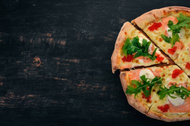 Somon ve havyar pizza. Deniz ürünleri. İtalyan mutfağı. Ahşap bir arka plan üzerinde. Metin için özgür yer. Üstten görünüm.