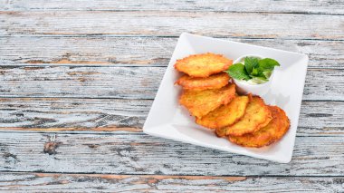 Patatesli Çörek ekşi krema ile. Patatesli krep. Ukraynalı mutfağı. Eski ahşap arka plan üzerinde. Metin için özgür yer. Üstten görünüm.