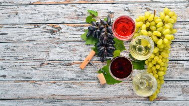 kırmızı ve beyaz şarap gözlük. Üzüm. Beyaz ahşap zemin üzerinde. Metin için özgür yer. Üstten görünüm.