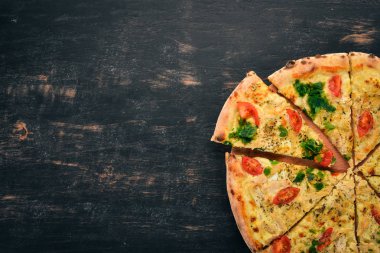 Pizza domates, suluguni peynir ve fesleğen. İtalyan mutfağı. Ahşap bir arka plan üzerinde. Metin için özgür yer. Üstten görünüm.