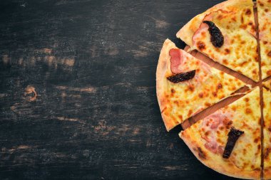 Pizza jambon, füme domates ve mozzarella peyniri. İtalyan mutfağı. Ahşap bir arka plan üzerinde. Metin için özgür yer. Üstten görünüm.