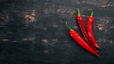 Kırmızı biber. Siyah ahşap arka plan üzerinde. Metin için özgür yer. Üstten görünüm.