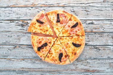 Pizza jambon, füme domates ve mozzarella peyniri. İtalyan mutfağı. Ahşap bir arka plan üzerinde. Metin için özgür yer. Üstten görünüm.