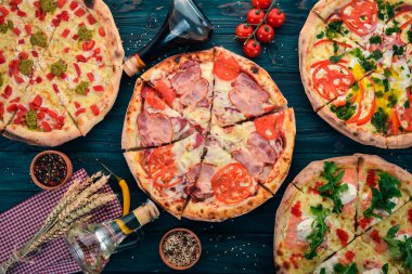 İtalyan yemeği arka plan. Pizza ürün yelpazesine. Siyah ahşap arka plan üzerinde. Metin için özgür yer. Üstten görünüm.