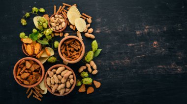 Aperatif bira için. Tuzlu kraker, cips, fındık, fıstık, fıstık. Ahşap bir arka plan üzerinde. Metin için özgür yer. Üstten görünüm.