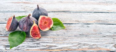 İncir. Beyaz ahşap bir masa üzerinde incir, taze meyve. Metin için özgür yer. Üstten görünüm.