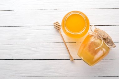 Beyaz ahşap zemin üzerinde bir kavanoza tatlım. Metin için özgür yer. Üstten görünüm.