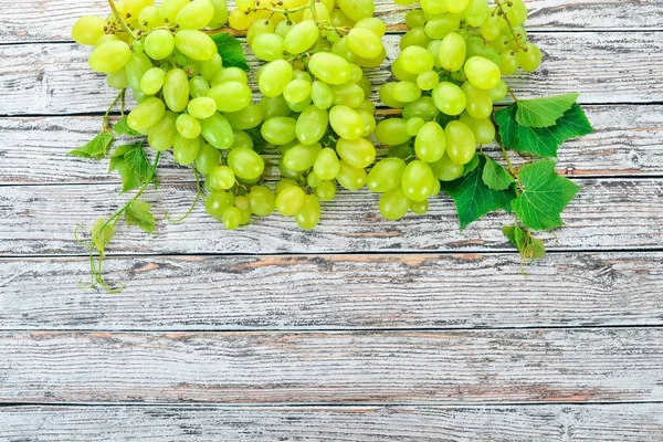 Üzüm. Beyaz ahşap zemin üzerinde taze beyaz üzüm. Üstten görünüm. Metin için boş alan.