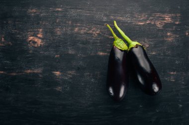 Patlıcan. Siyah ahşap arka plan üzerinde. Metin için özgür yer. Üstten görünüm.