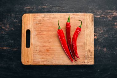 Kırmızı biber. Siyah ahşap arka plan üzerinde. Metin için özgür yer. Üstten görünüm.