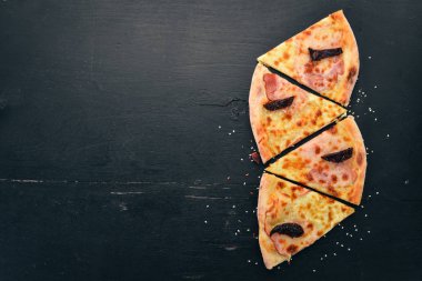 Pizza jambon, füme domates ve mozzarella peyniri. İtalyan mutfağı. Ahşap bir arka plan üzerinde. Metin için özgür yer. Üstten görünüm.