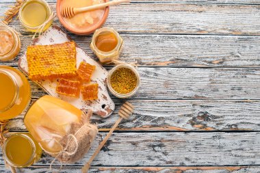 Arı ürünleri ve bal beyaz ahşap zemin üzerinde kümesi. Metin için özgür yer. Üstten görünüm.