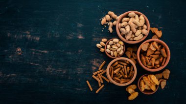 Aperatif bira için. Tuzlu kraker, cips, fındık, fıstık, fıstık. Ahşap bir arka plan üzerinde. Metin için özgür yer. Üstten görünüm.