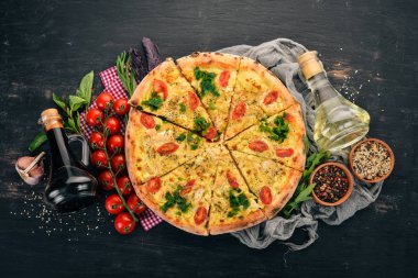 Pizza domates, suluguni peynir ve fesleğen. İtalyan mutfağı. Ahşap bir arka plan üzerinde. Metin için özgür yer. Üstten görünüm.