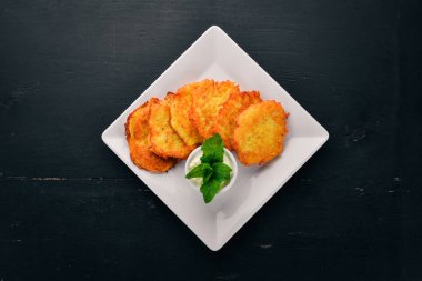 Patatesli Çörek ekşi krema ile. Patatesli krep. Ukraynalı mutfağı. Eski ahşap arka plan üzerinde. Metin için özgür yer. Üstten görünüm.