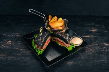 Fırında patates ve et, domates ve soğan ile Burger. Ahşap bir arka plan üzerinde. Metin için özgür yer. Üstten görünüm.
