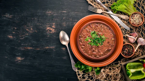 Bean. Haricot Soup. Georgian traditional cuisine. On the old wooden background. Free space for text. Top view. — Stock Image Bean Haricot Soup Georgian Traditional Cuisine Old Wooden Background Free Stock Picture