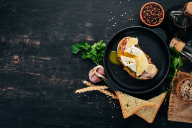 Haşlanmış yumurta, avokado ve parmesan peynirli sandviç. Ahşap bir arka plan üzerinde. Metin için özgür yer. Üstten görünüm.