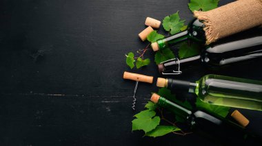 Kırmızı ve beyaz şarap şişeleri ve gözlük kümesi. Üzüm. Siyah ahşap arka plan üzerinde. Metin için özgür yer. Üstten görünüm.