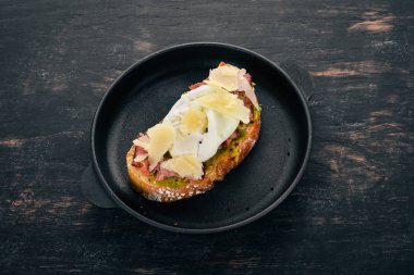 Haşlanmış yumurta, avokado ve parmesan peynirli sandviç. Ahşap bir arka plan üzerinde. Metin için özgür yer. Üstten görünüm.