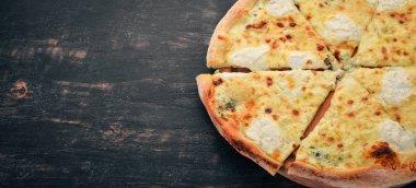 Pizza Quattro Formaggi. İtalyan mutfağı. Ahşap bir arka plan üzerinde. Metin için özgür yer. Üstten görünüm.