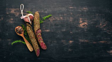 Sosis Fuet. Salam baharatlar ile. Siyah bir arka plan üzerinde. Üstten görünüm. Metniniz için boş alan.