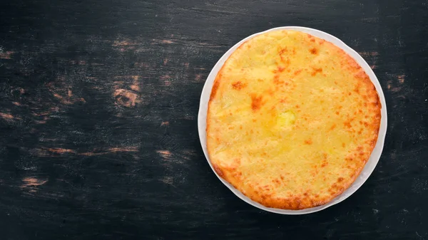 Khachapuri peynir ile. Gürcü mutfağı. Eski ahşap arka plan üzerinde. Metin için özgür yer. Üstten görünüm.