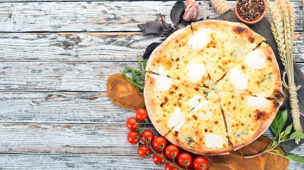 Pizza Quattro Formaggi. İtalyan mutfağı. Ahşap bir arka plan üzerinde. Metin için özgür yer. Üstten görünüm.