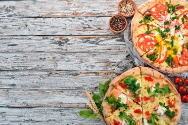 Pizza. İtalyan mutfağı. Beyaz ahşap zemin üzerinde. Metin için özgür yer. Üstten görünüm.