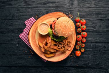 Hamburger eti, soğan, domates ve fırında patates ile. Eski arka plan üzerinde. Ücretsiz kopya alanı. Üstten görünüm.