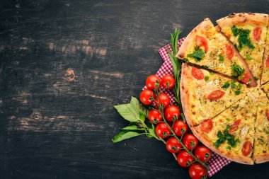 Pizza domates, suluguni peynir ve fesleğen. İtalyan mutfağı. Ahşap bir arka plan üzerinde. Metin için özgür yer. Üstten görünüm.