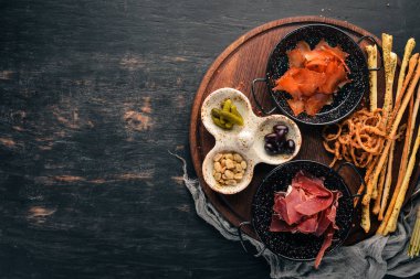 Aperatifler bira için bir seçim. Balık, prosciutto, yer fıstığı, zeytin. Ahşap bir arka plan üzerinde. Ücretsiz kopya alanı. Üstten görünüm.